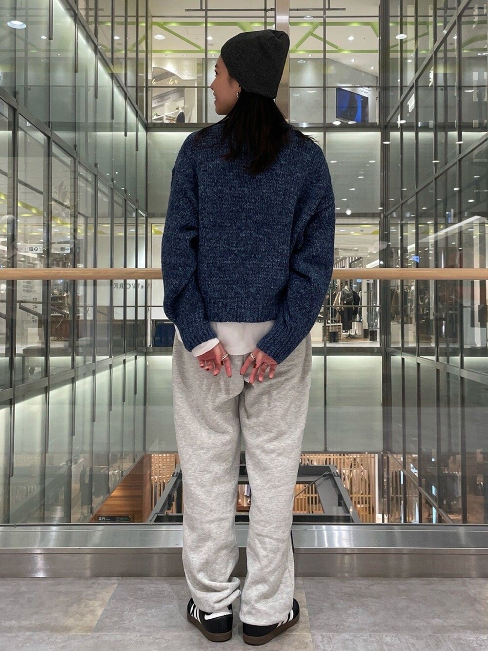 ブルー系のニット/セーター、ホワイト系のTシャツ/カットソー、グレー系のスウェットパンツを着用したレディースの秋コーディネートの3枚目の写真