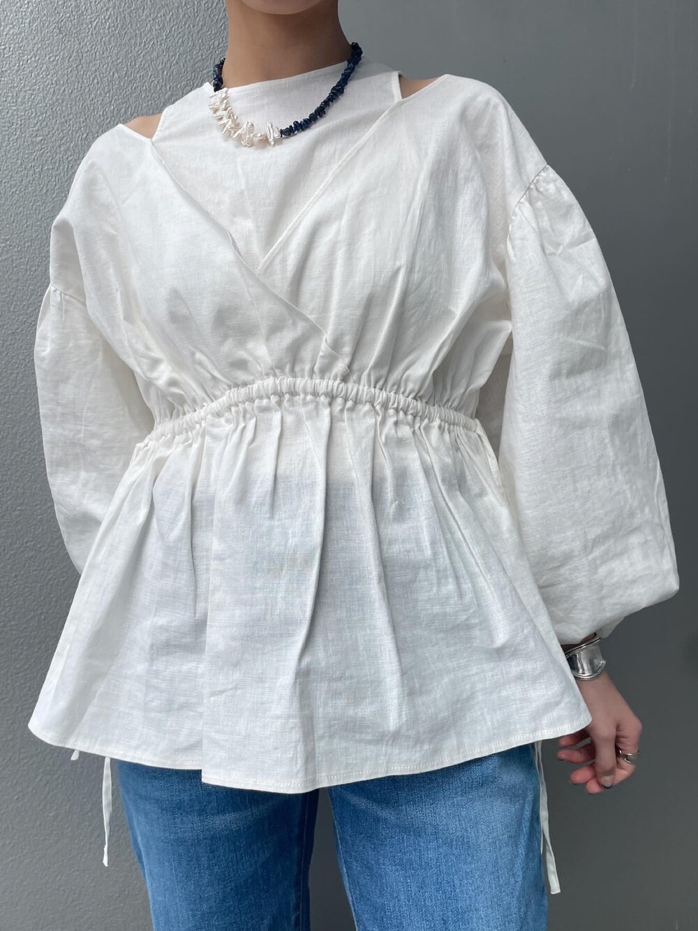 ブルー系のデニムパンツ、ホワイト系のシャツ/ブラウス、ゴールド系のパンプスを着用したレディースの春コーディネートの2枚目の写真