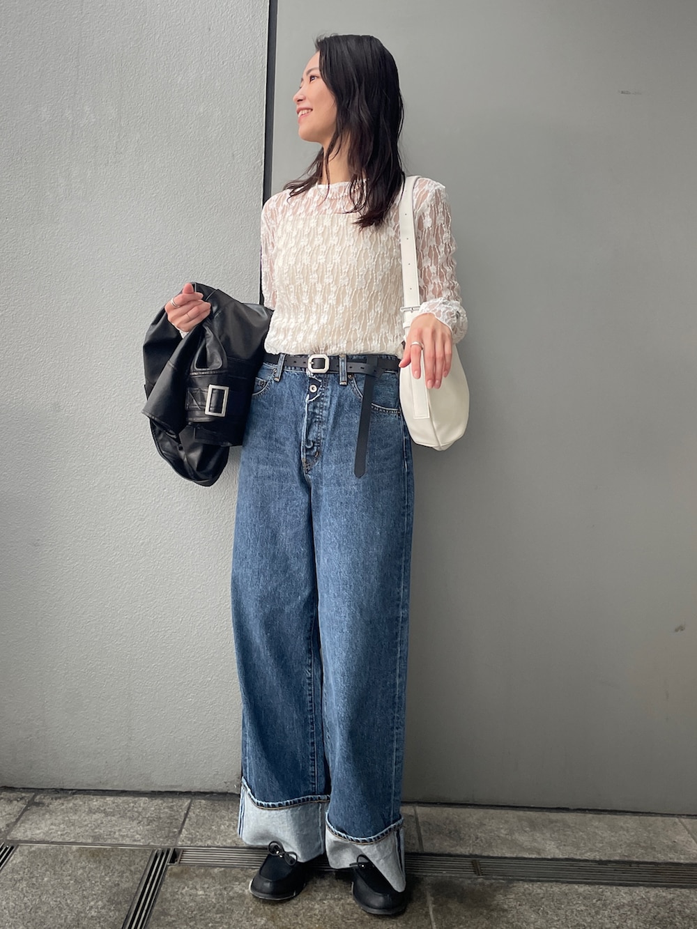 ブルー系のデニムパンツ、ブラック系のブルゾン、ブラック系のローファーを着用したレディースの冬コーディネートの4枚目の写真