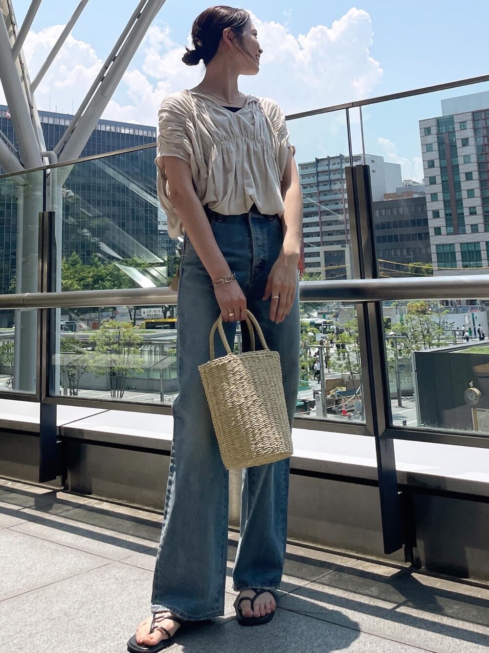 ホワイト系のシャツ/ブラウス、ブルー系のデニムパンツ、ベージュ系のかごバッグを着用したレディースの夏コーディネートの2枚目の写真