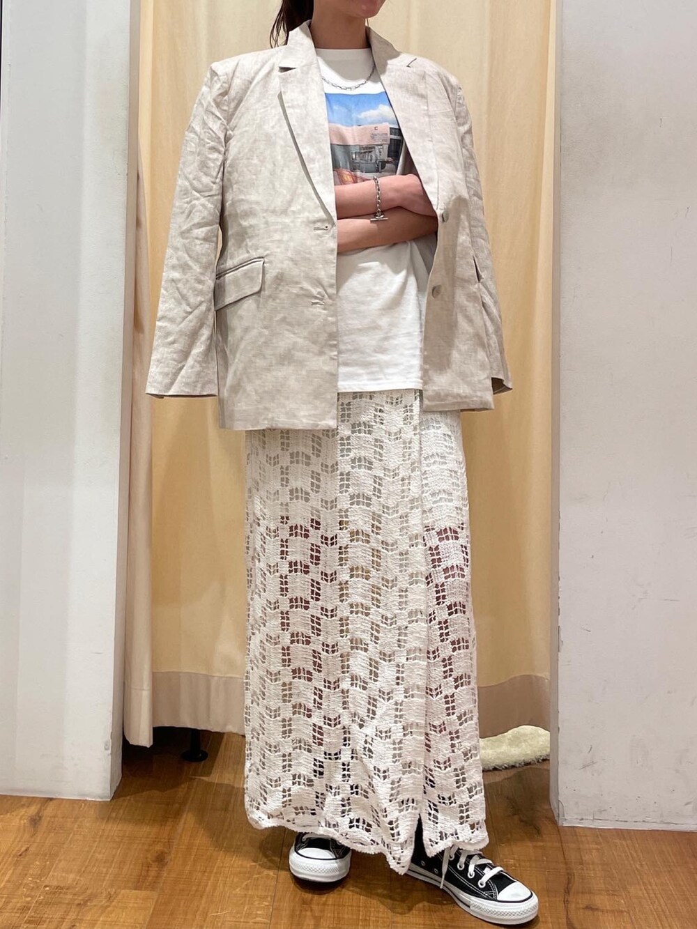 ホワイト系のTシャツ/カットソー、ベージュ系のテーラードジャケット、ホワイト系のスカートを着用したレディースの春コーディネートの2枚目の写真