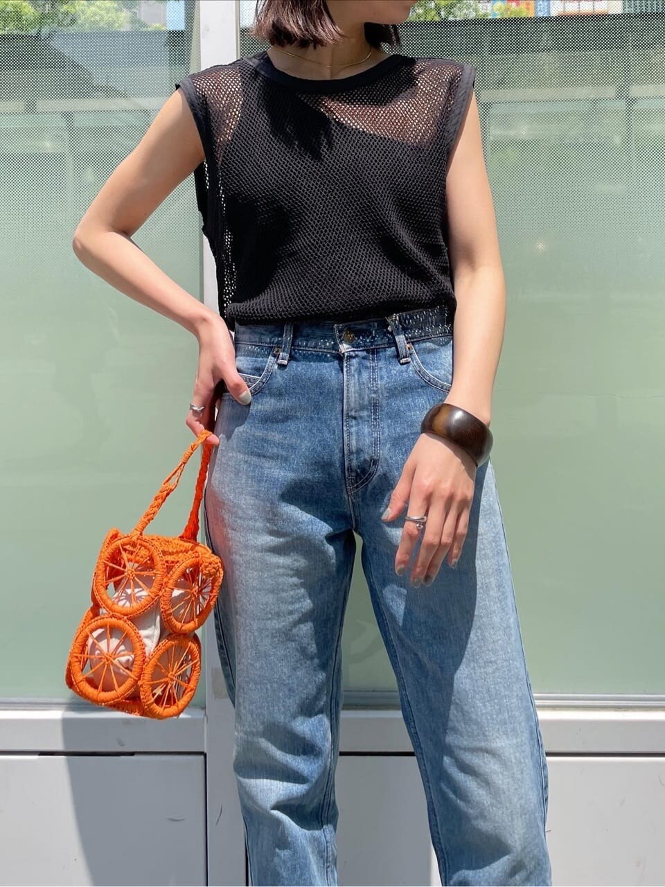 ブラック系のタンクトップ、ブルー系のデニムパンツ、ブラック系のタンクトップを着用したレディースの春コーディネートの2枚目の写真