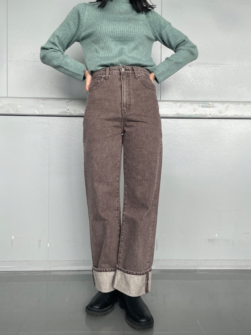 ブラウン系のデニムパンツ、グリーン系のニット/セーターを着用したレディースの冬コーディネートの2枚目の写真