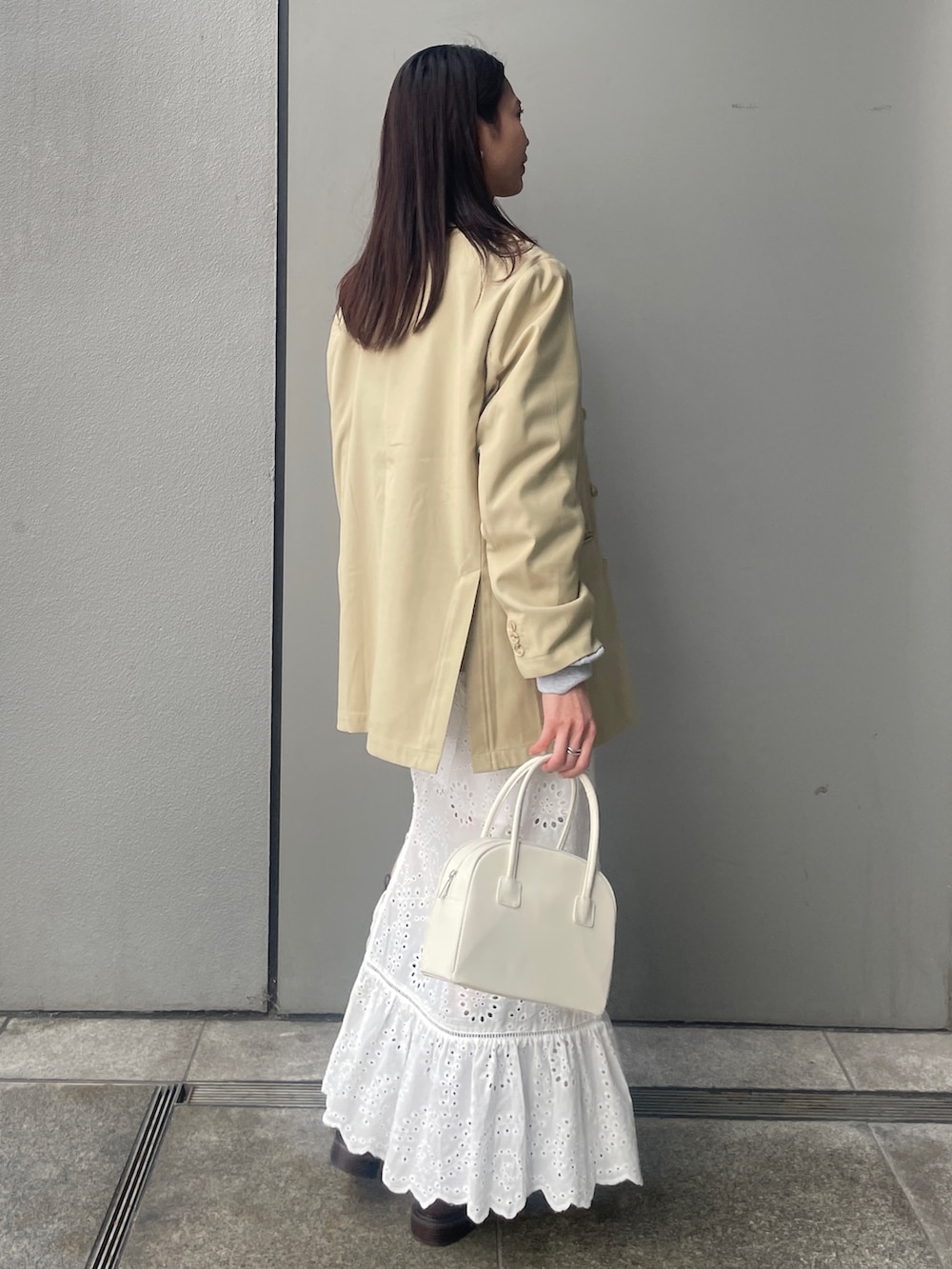 ベージュ系のテーラードジャケット、グレー系のスウェット、ブラウン系のブーツを着用したレディースの冬コーディネートの3枚目の写真