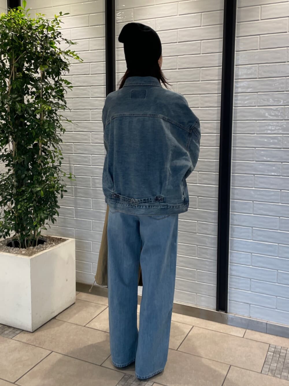 ブルー系のデニムパンツ、ブルー系のデニムジャケット、イエロー系のニット/セーターを着用したレディースの冬コーディネートの3枚目の写真