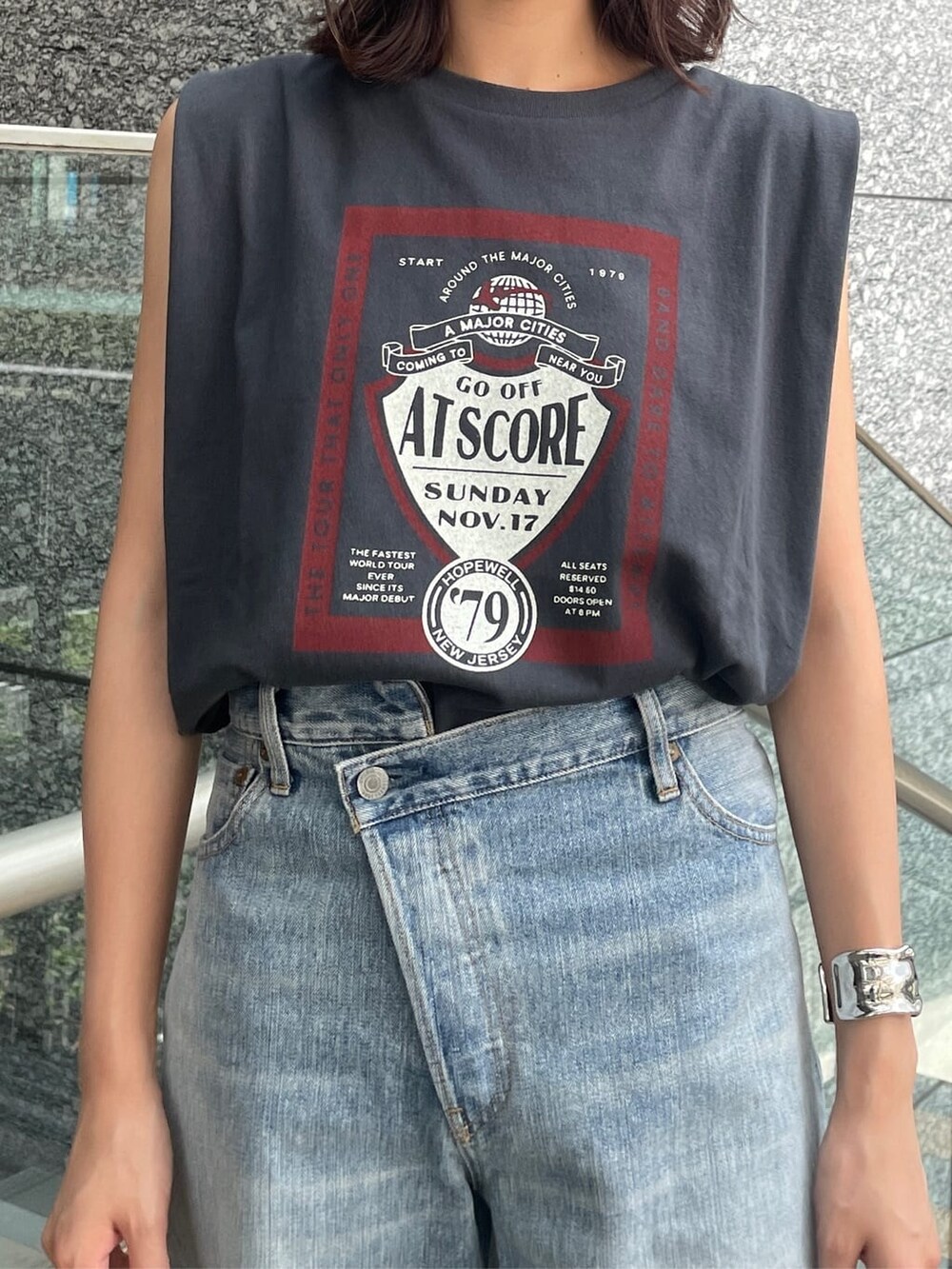 グレー系のタンクトップ、ブラック系のサンダル、ブルー系のデニムパンツを着用したレディースの夏コーディネートの3枚目の写真