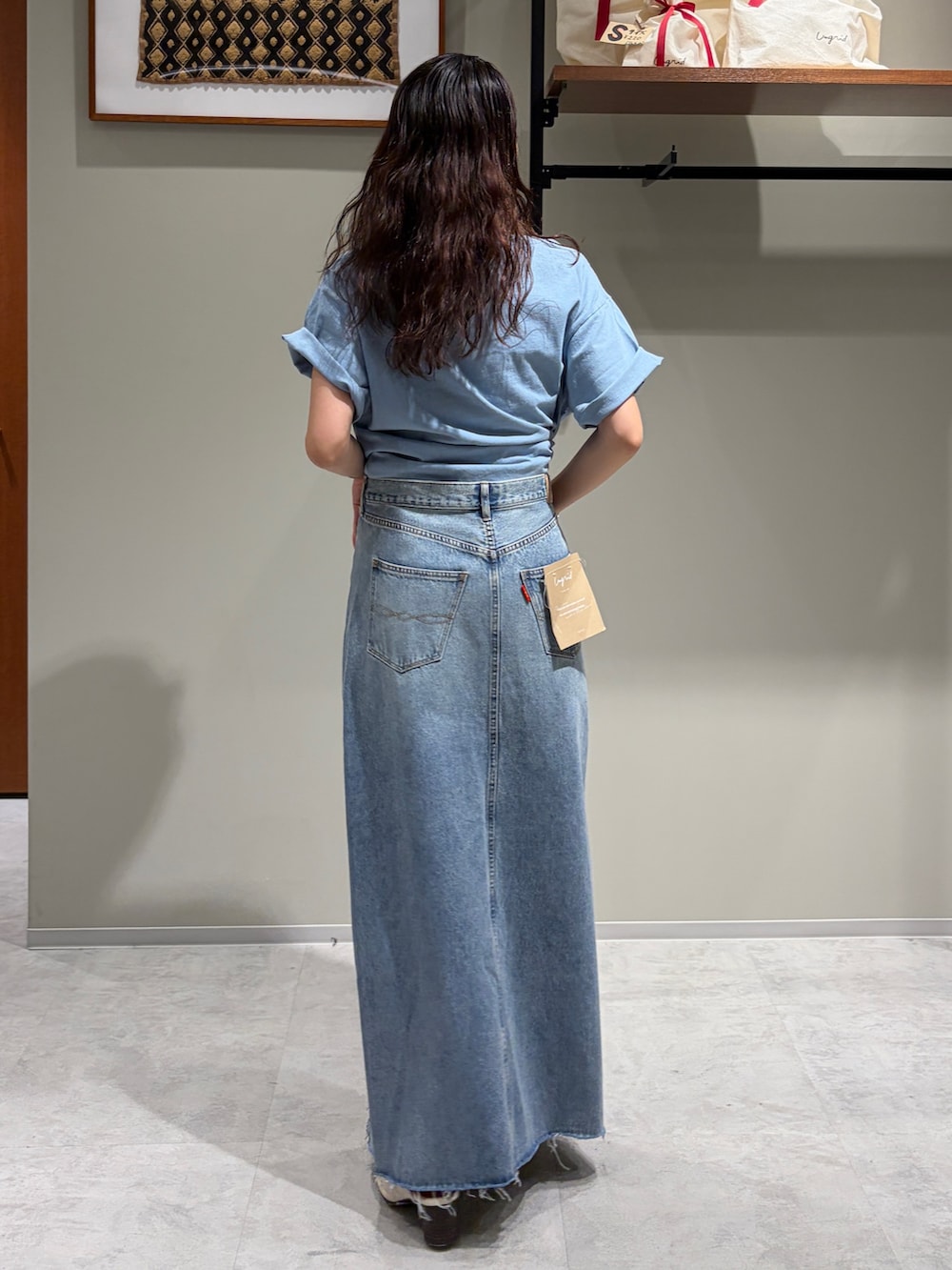 ブルー系のデニムスカート、ブルー系のTシャツ/カットソー、ホワイト系のサンダルを着用したレディースの春コーディネートの3枚目の写真