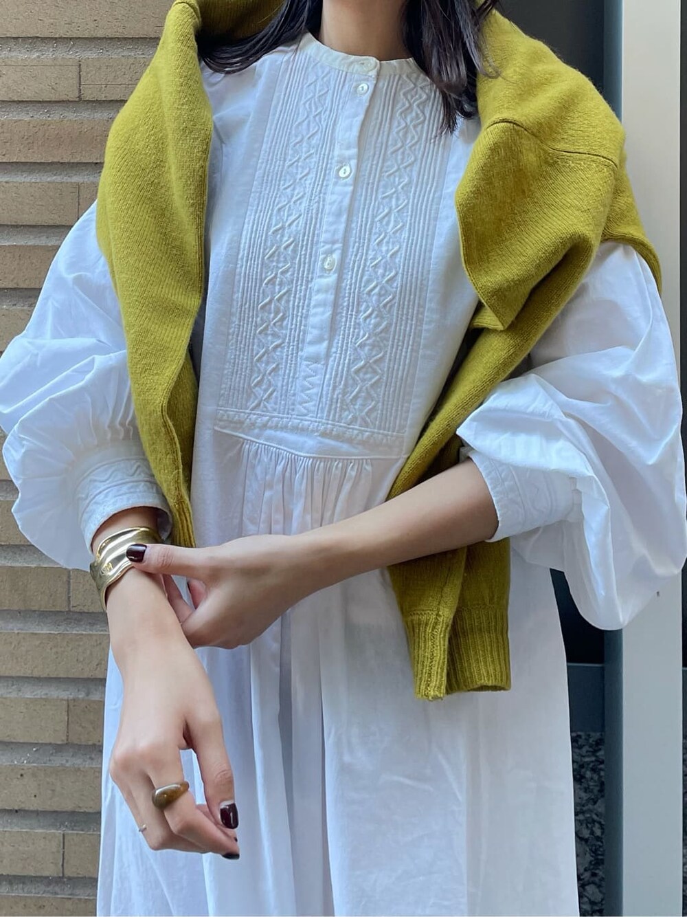 ブラック系のブーツ、ホワイト系のワンピース、グリーン系のニット/セーターを着用したレディースの秋コーディネートの2枚目の写真