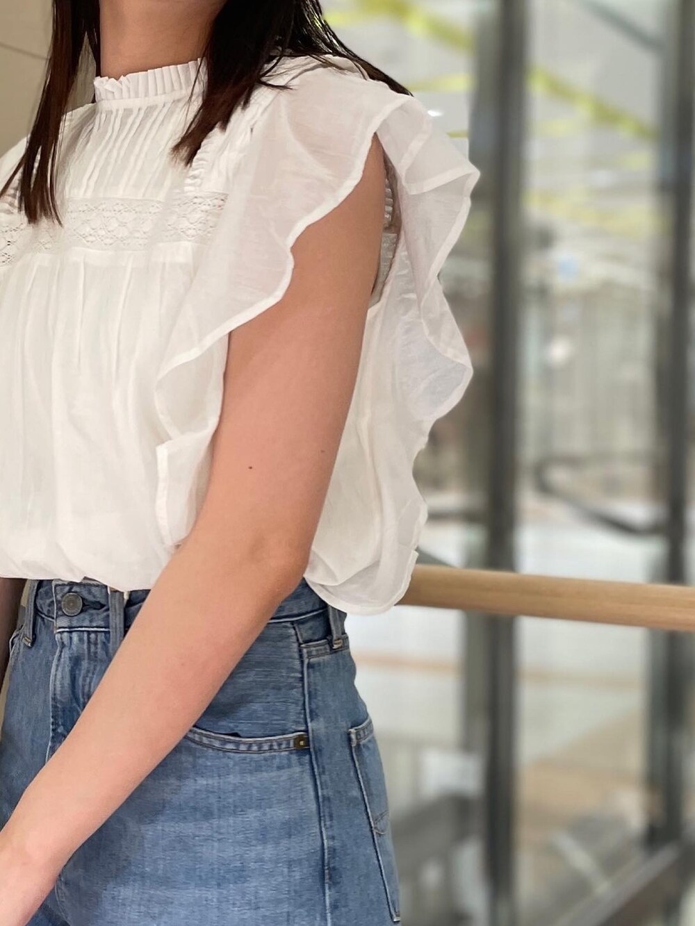 ブルー系のデニムパンツ、ホワイト系のシャツ/ブラウス、ホワイト系のサンダルを着用したレディースの夏コーディネートの2枚目の写真