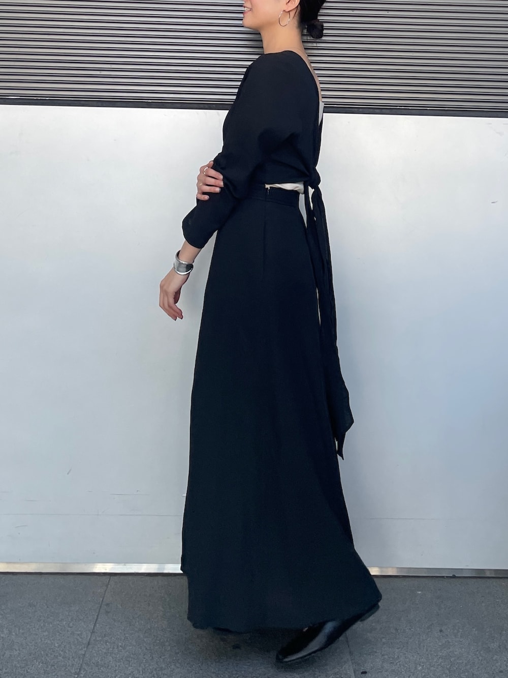 ブラック系のワンピース、ブラック系のパンプスを着用したレディースの春コーディネートの3枚目の写真