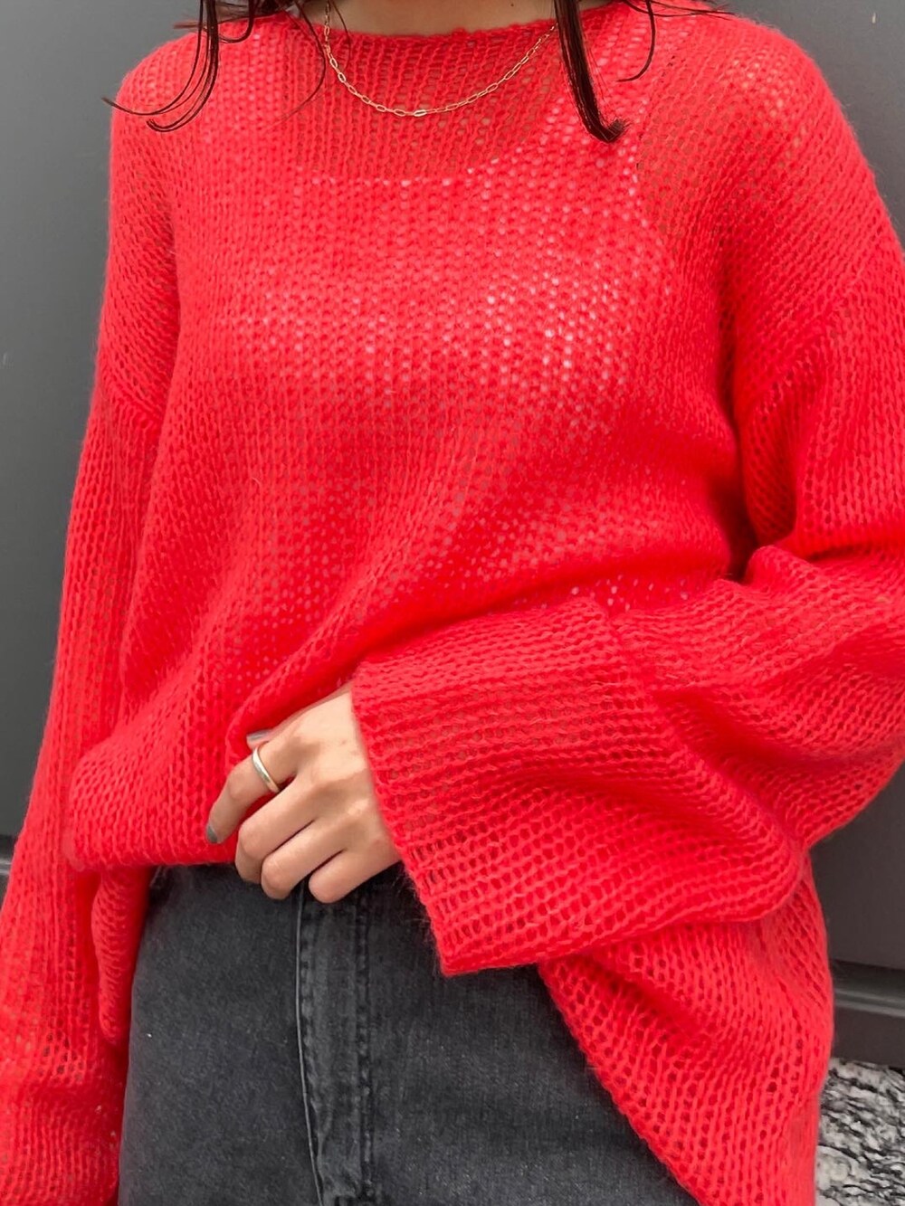 ブラック系のデニムパンツ、オレンジ系のニット/セーターを着用したレディースの冬コーディネートの2枚目の写真