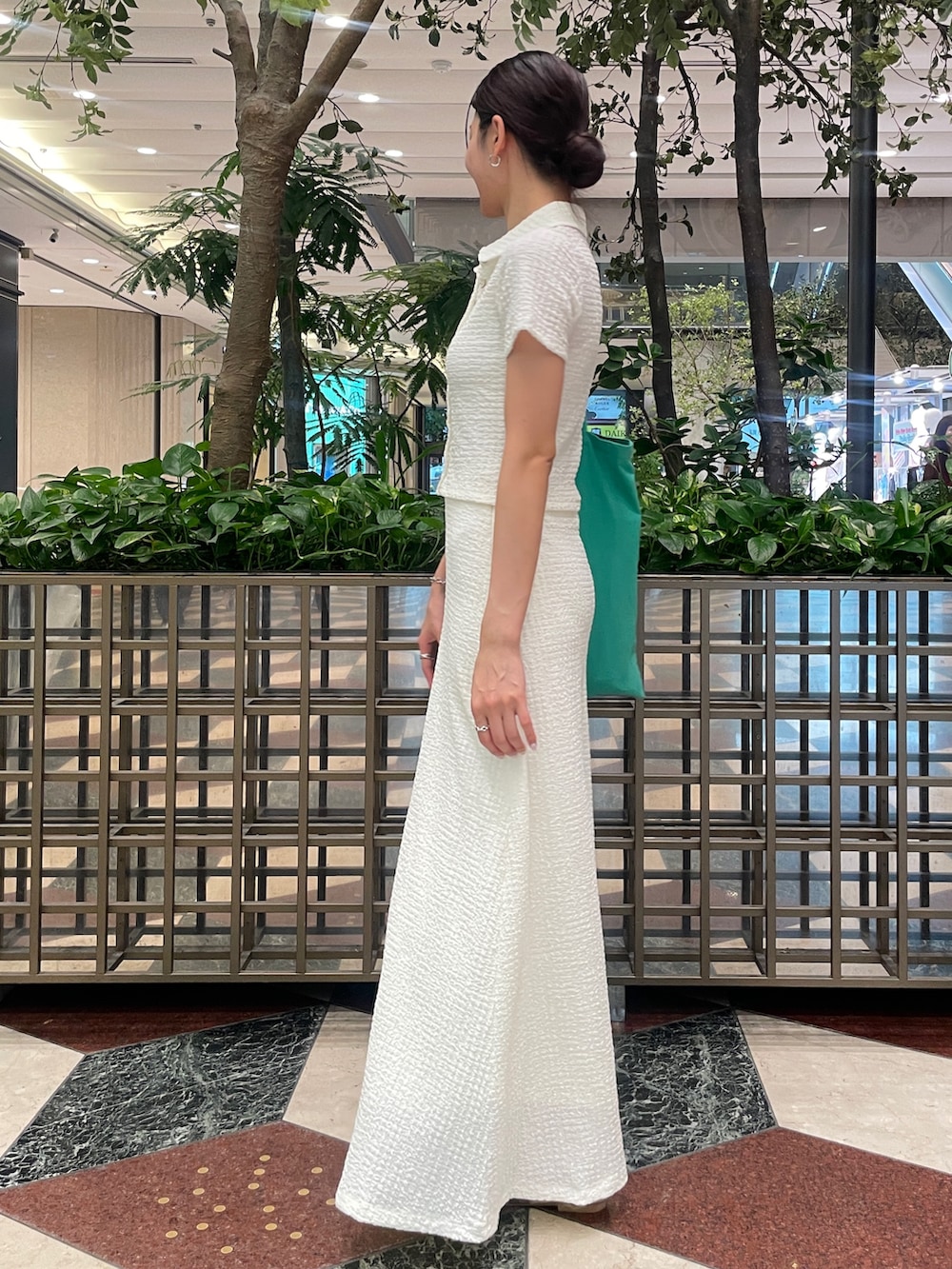 ホワイト系のスカート、ホワイト系のポロシャツ、ゴールド系のバレエシューズを着用したレディースの夏コーディネートの2枚目の写真