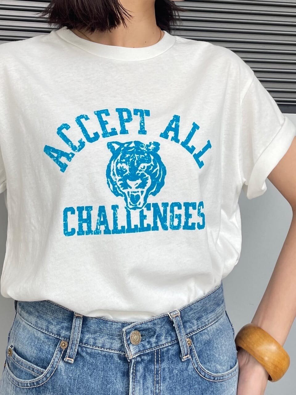 ホワイト系のTシャツ/カットソー、ブルー系のデニムパンツ、ブラウン系のブレスレットを着用したレディースの春コーディネートの4枚目の写真