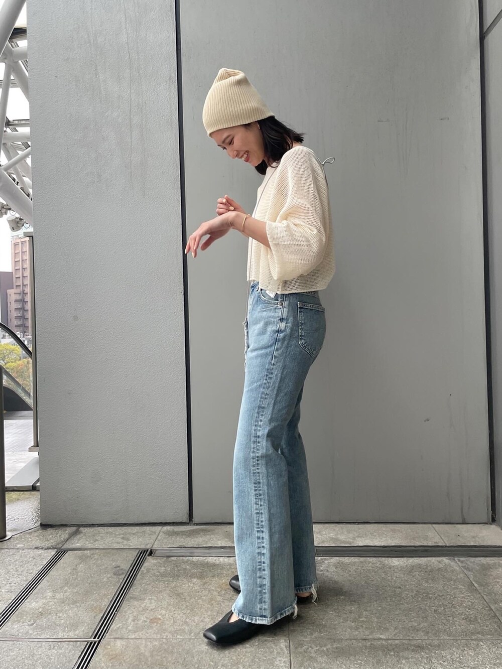 ブルー系のデニムパンツ、ホワイト系のTシャツ/カットソー、ブラック系のパンプスを着用したレディースの春コーディネートの3枚目の写真
