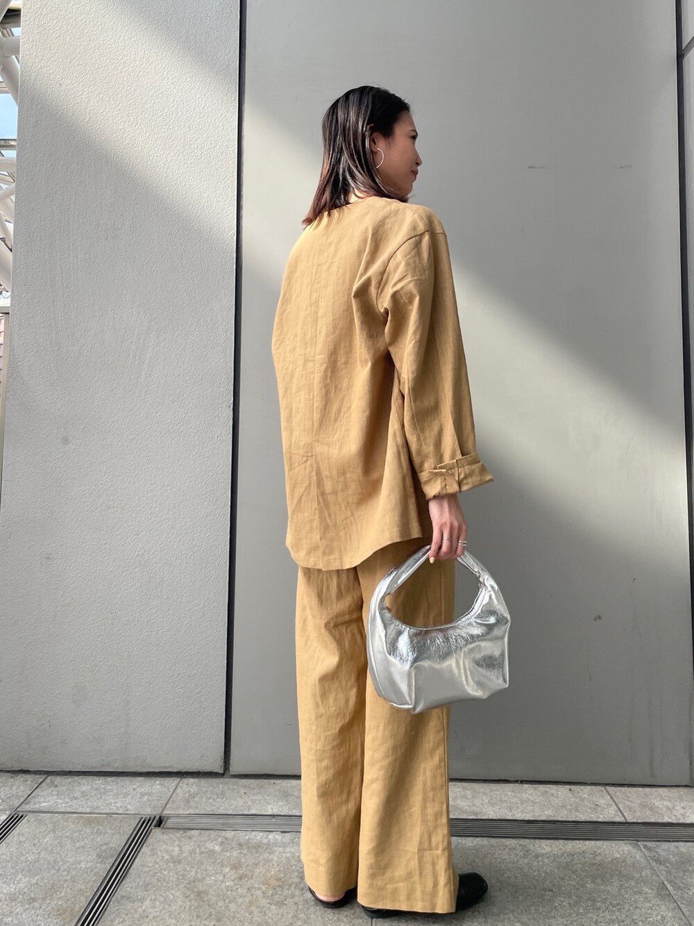 ベージュ系のテーラードジャケット、ベージュ系のその他パンツ、ホワイト系のキャミソールを着用したレディースの春コーディネートの7枚目の写真