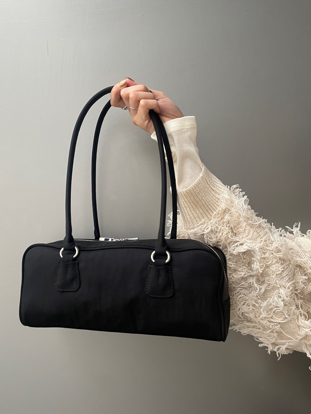 ホワイト系のニット/セーター、ブラック系のスカート、ブラック系のブーツを着用したレディースの秋コーディネートの5枚目の写真