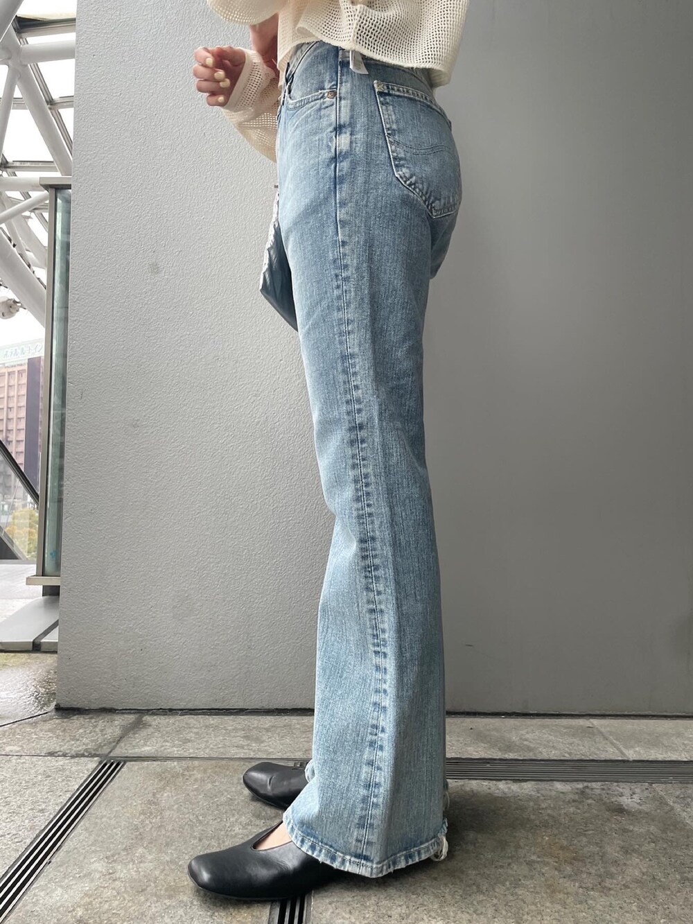 ブルー系のデニムパンツ、ホワイト系のTシャツ/カットソー、ブラック系のパンプスを着用したレディースの春コーディネートの5枚目の写真