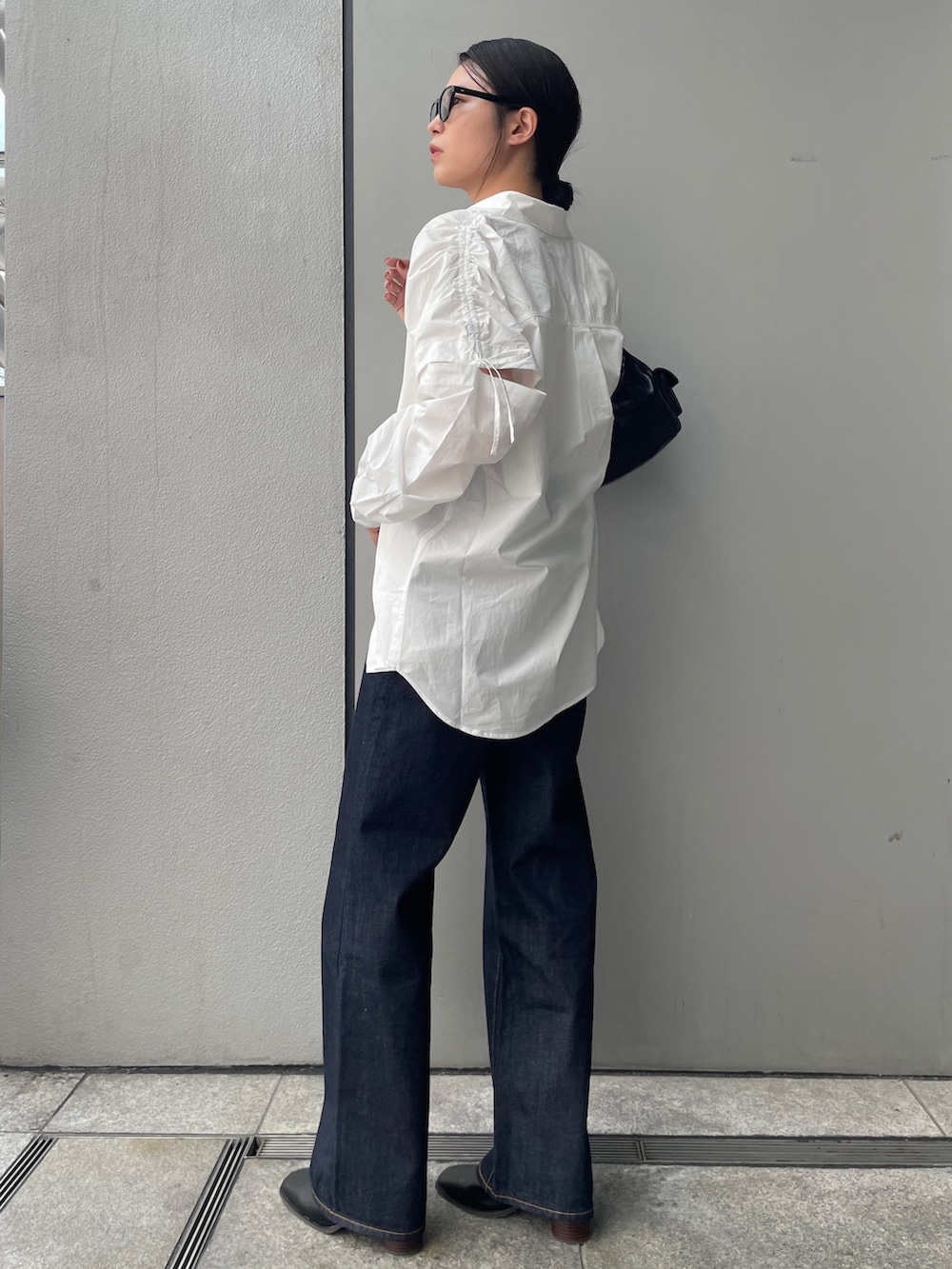 ブルー系のデニムパンツ、ホワイト系のシャツ/ブラウス、ホワイト系のキャミソールを着用したレディースの夏コーディネートの4枚目の写真