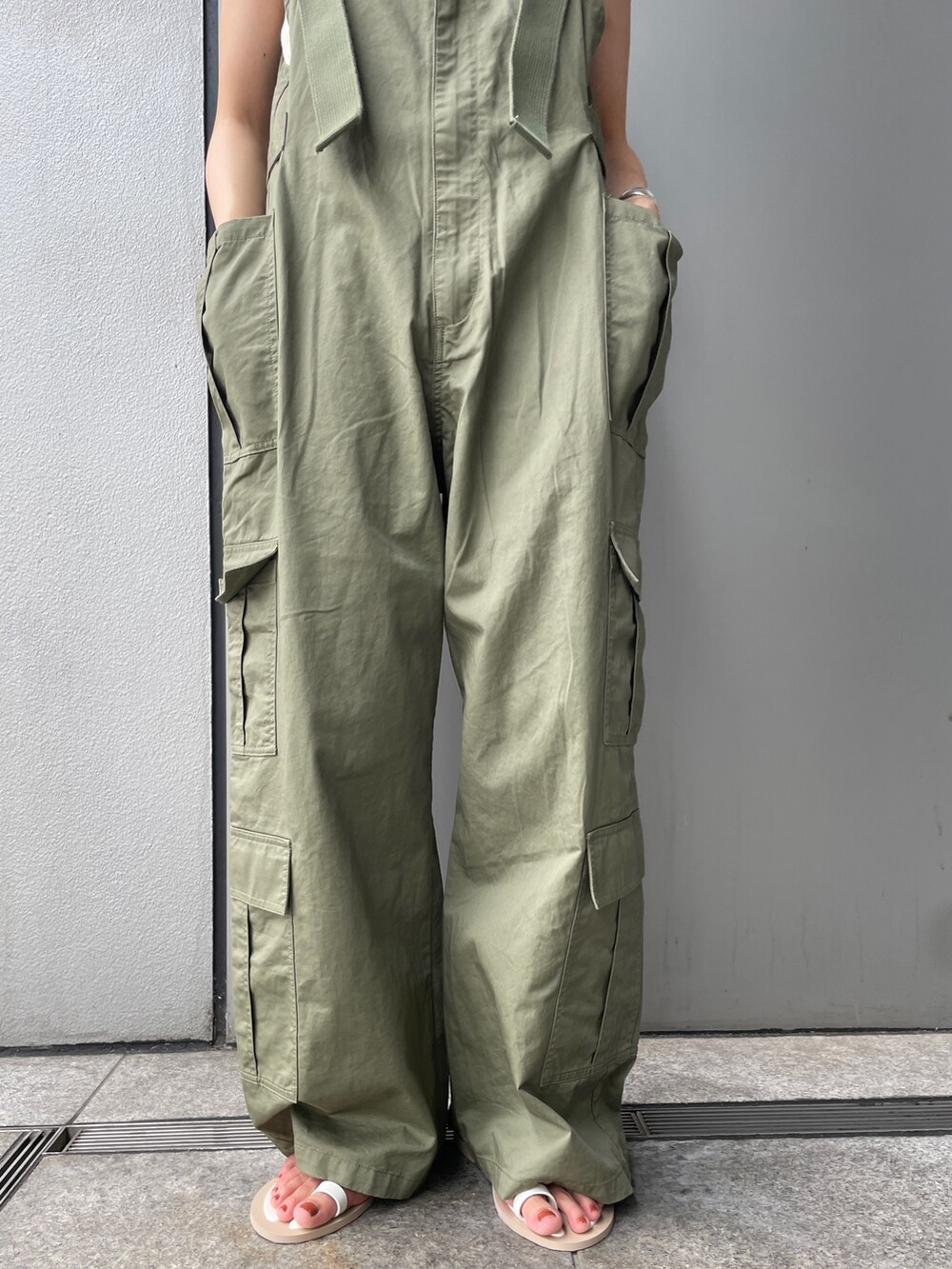 グリーン系のサロペット/オーバーオール、ブラウン系のベスト、ホワイト系のキャミソールを着用したレディースの夏コーディネートの4枚目の写真