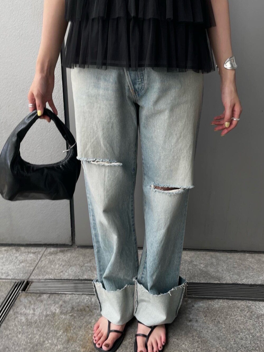 ブラック系のシャツ/ブラウス、ブルー系のデニムパンツを着用したレディースの夏コーディネートの6枚目の写真