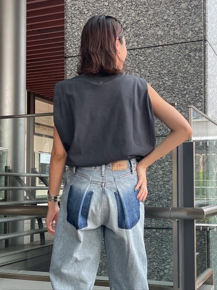 グレー系のタンクトップ、ブラック系のサンダル、ブルー系のデニムパンツを着用したレディースの夏コーディネートの2枚目の写真