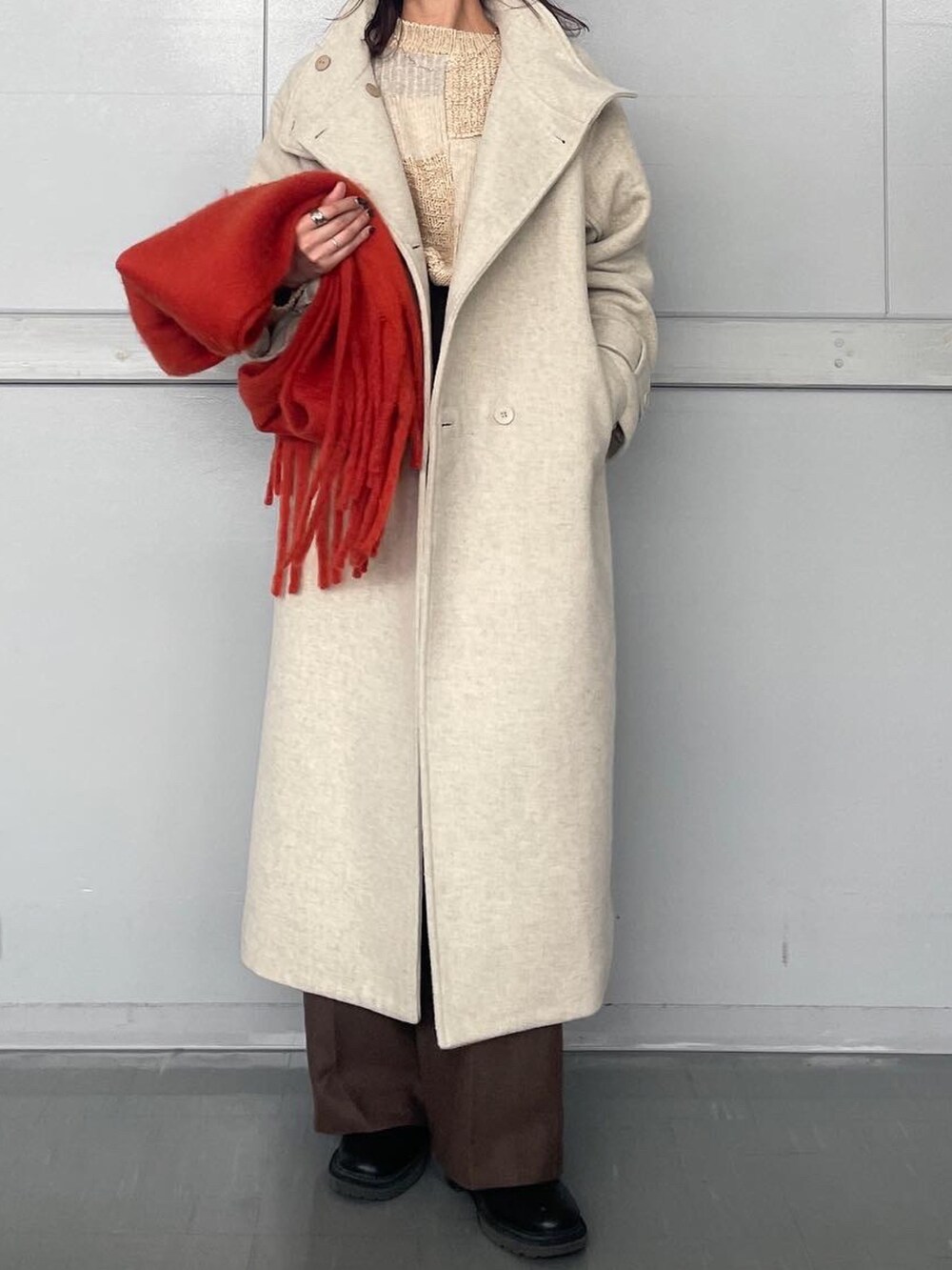 ホワイト系のその他アウター、ブラウン系のその他パンツ、オレンジ系のマフラーを着用したレディースの秋コーディネートの2枚目の写真