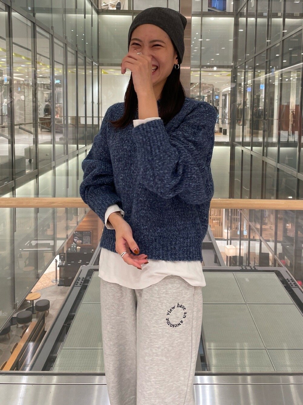 ブルー系のニット/セーター、ホワイト系のTシャツ/カットソー、グレー系のスウェットパンツを着用したレディースの秋コーディネートの4枚目の写真