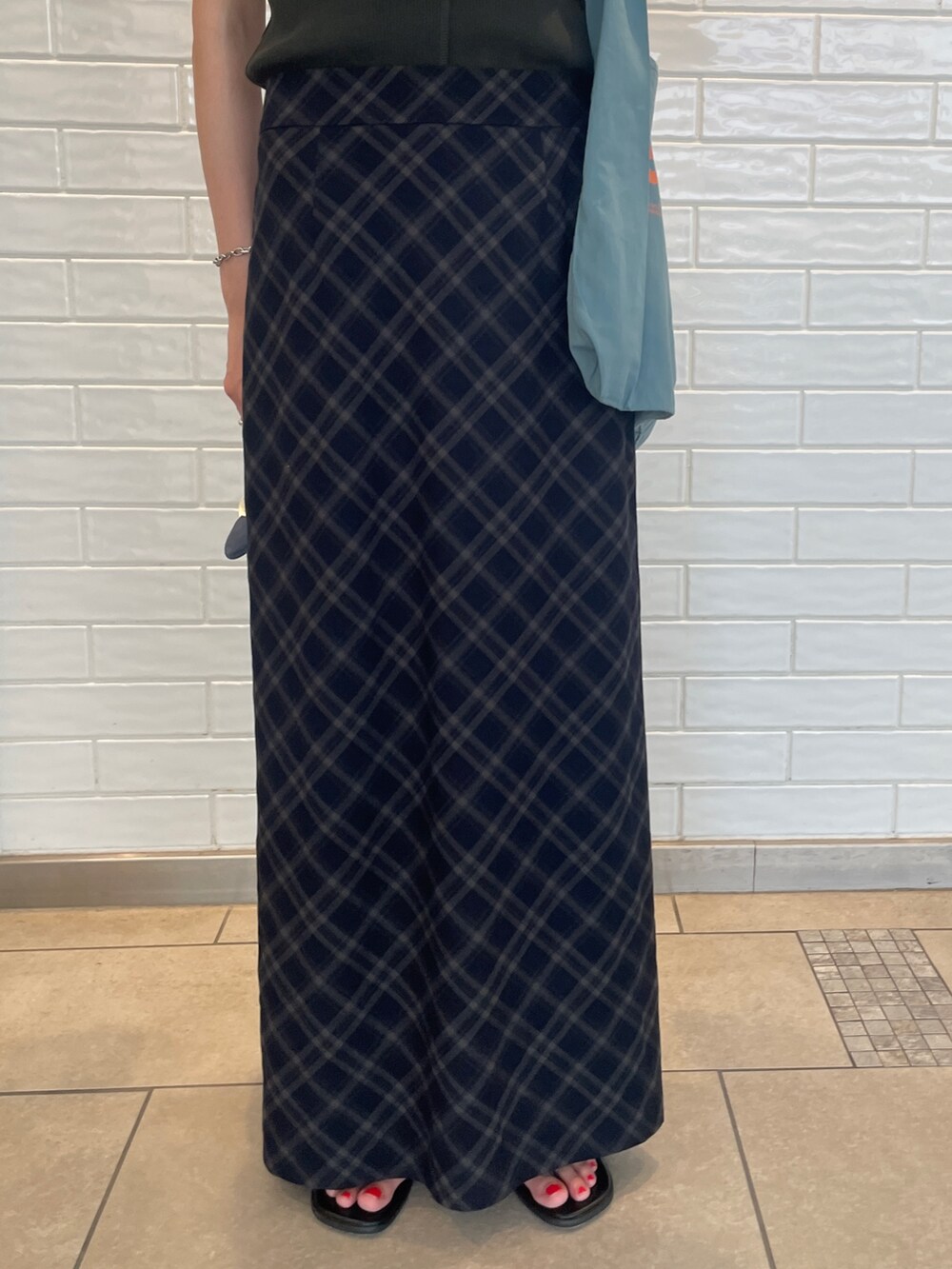 ブルー系のスカート、グレー系のタンクトップ、ブルー系のトートバッグを着用したレディースの夏コーディネートの4枚目の写真