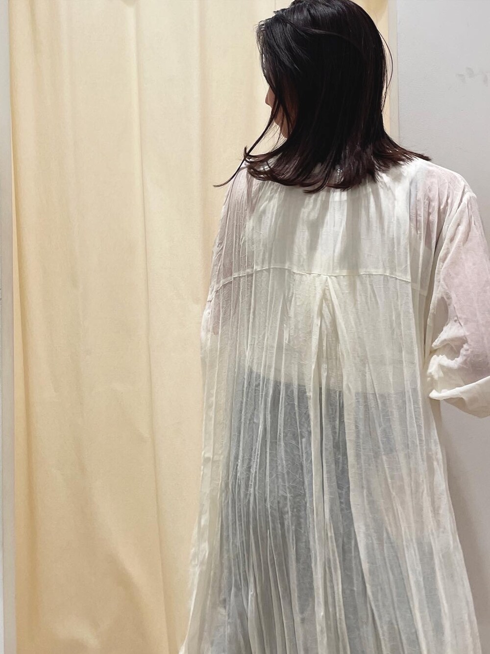 ホワイト系のワンピース、ブルー系のデニムパンツ、ホワイト系のスニーカーを着用したレディースの春コーディネートの4枚目の写真