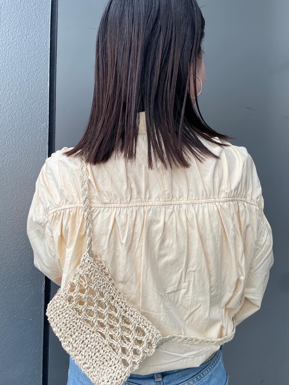 ブルー系のデニムパンツ、イエロー系のシャツ/ブラウス、ベージュ系のショルダーバッグを着用したレディースの春コーディネートの6枚目の写真