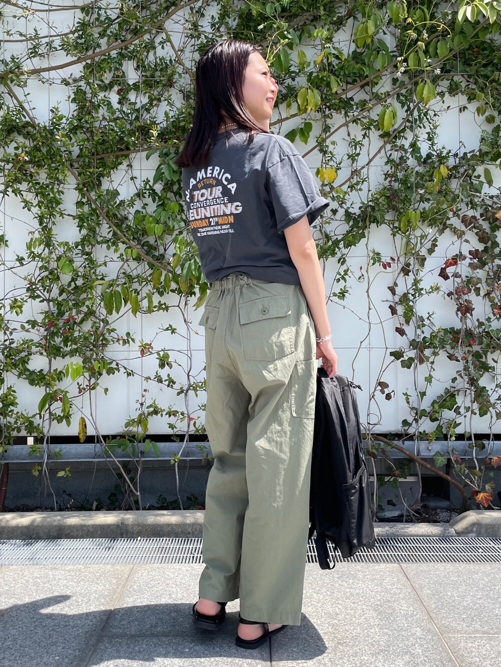 グレー系のTシャツ/カットソー、グリーン系のその他パンツ、ブラック系のサンダルを着用したレディースの春コーディネートの3枚目の写真