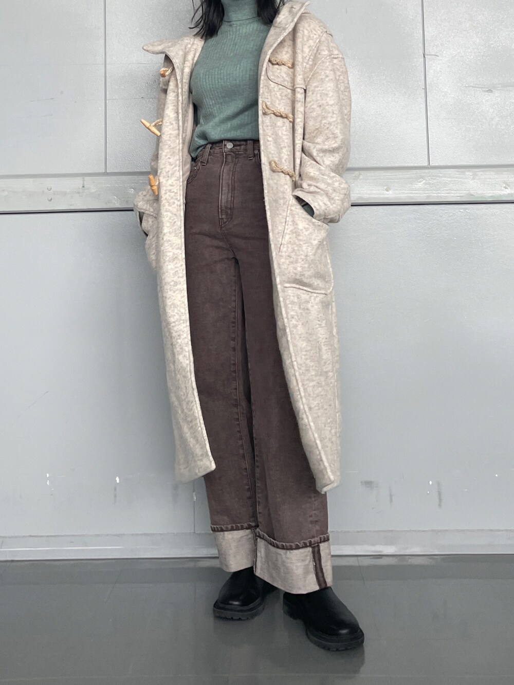 ブラウン系のデニムパンツ、グリーン系のニット/セーターを着用したレディースの冬コーディネートの3枚目の写真