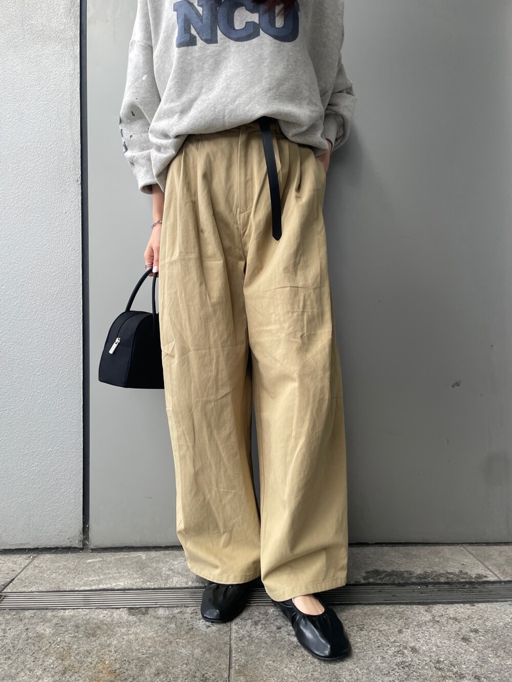 グレー系のスウェット、ベージュ系のチノパンツ、ブラック系のボストンバッグを着用したレディースの冬コーディネートの4枚目の写真