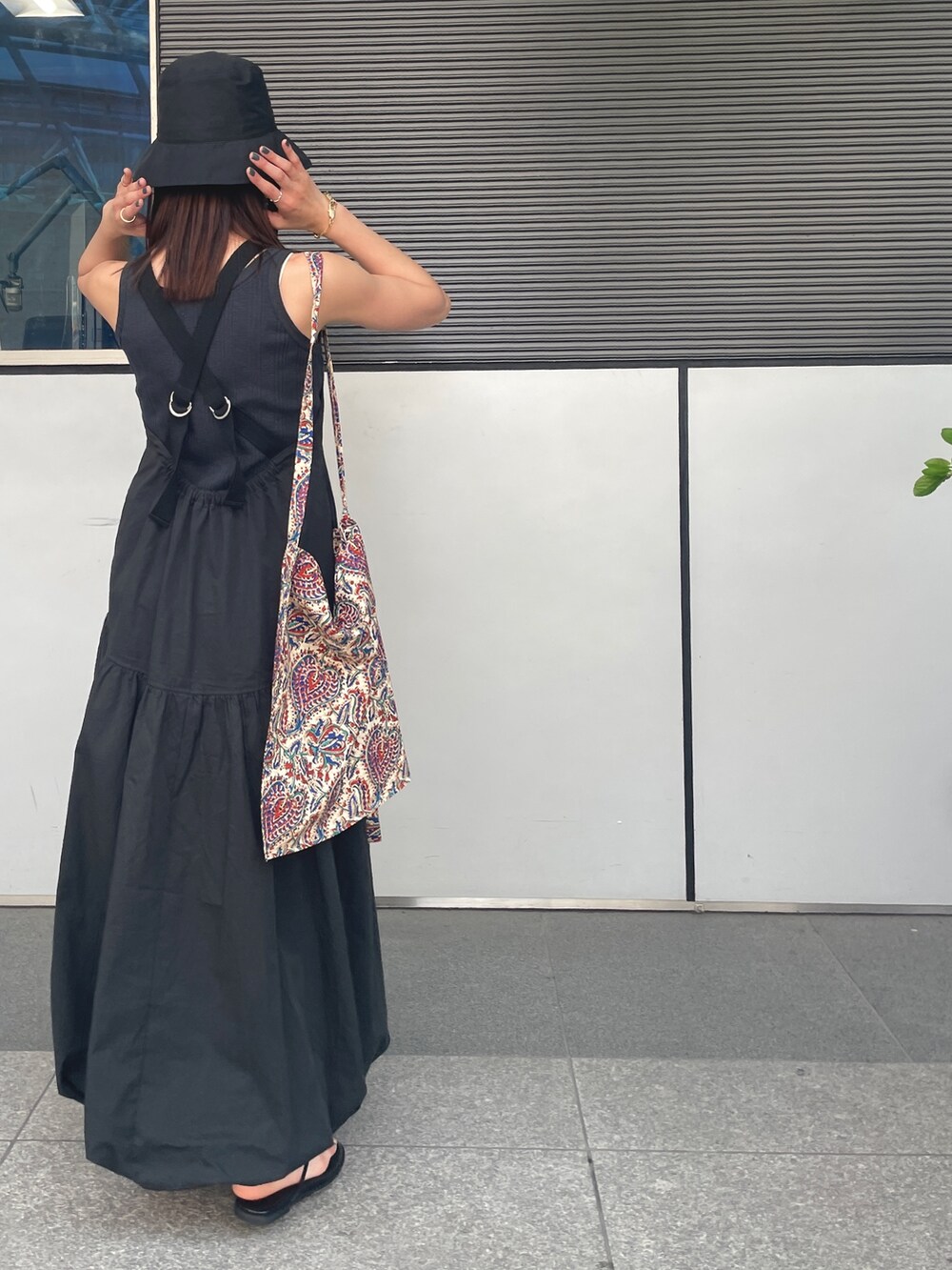 ブラック系のワンピース、ブラック系のサンダル、グレー系のタンクトップを着用したレディースの春コーディネートの3枚目の写真