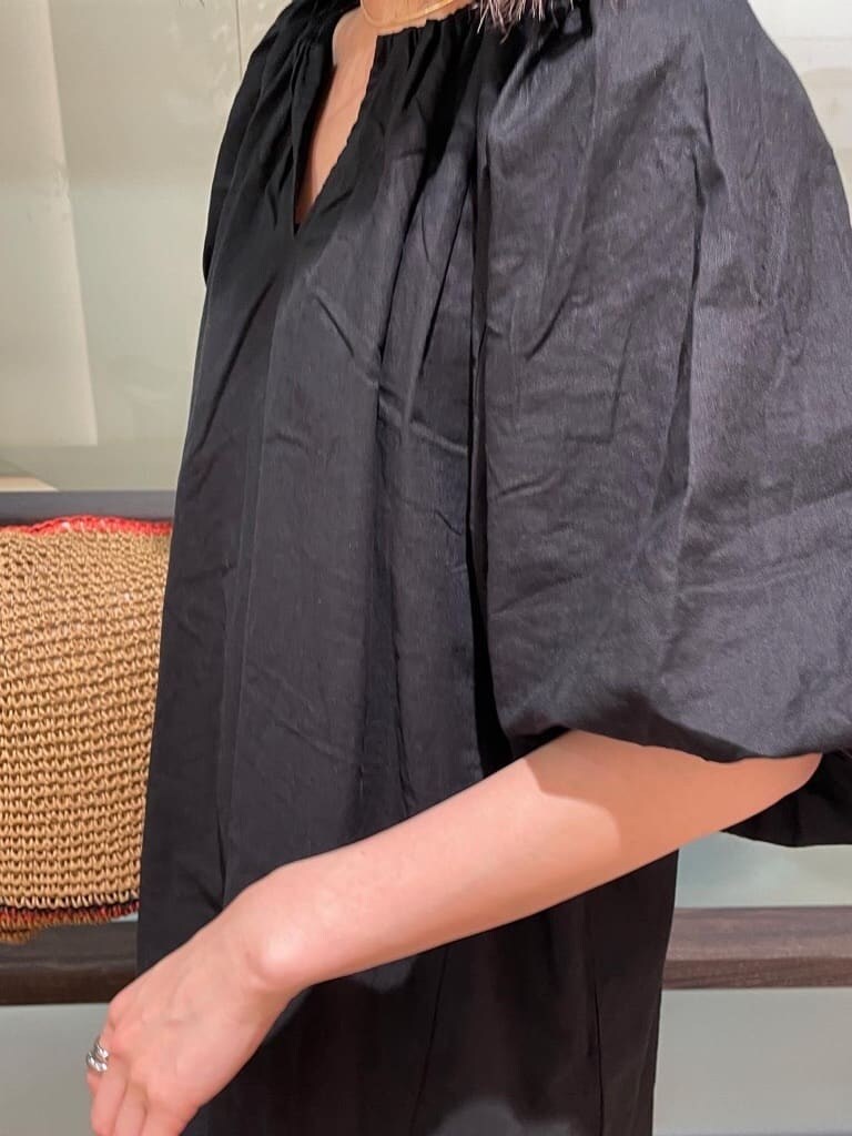 ブラック系のワンピース、ブラック系のサンダル、ベージュ系のトートバッグを着用したレディースの春コーディネートの4枚目の写真