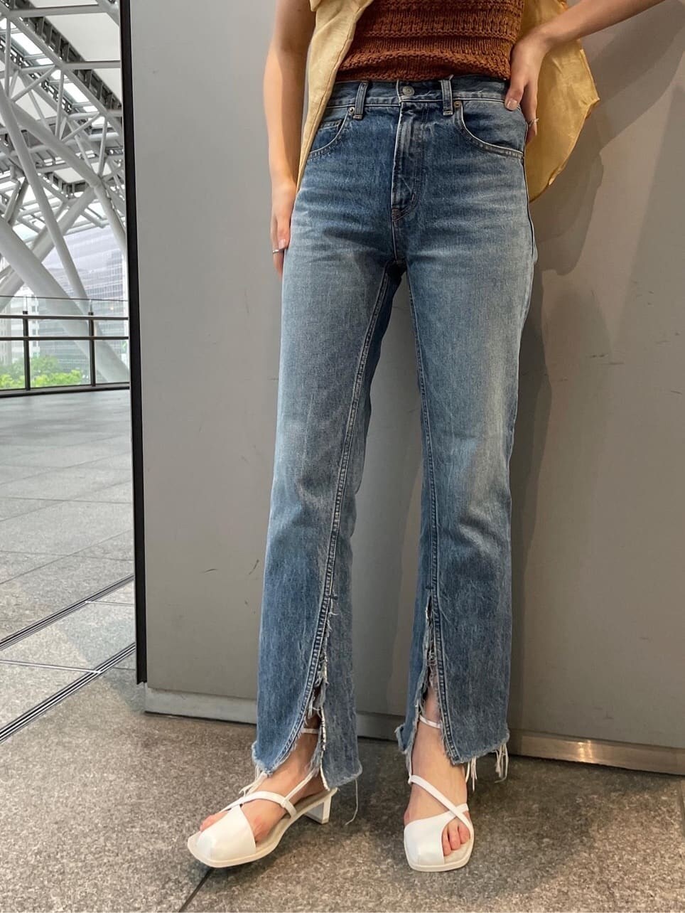 ブラウン系のシャツ/ブラウス、ホワイト系のサンダル、ブルー系のデニムパンツを着用したレディースの春コーディネートの3枚目の写真