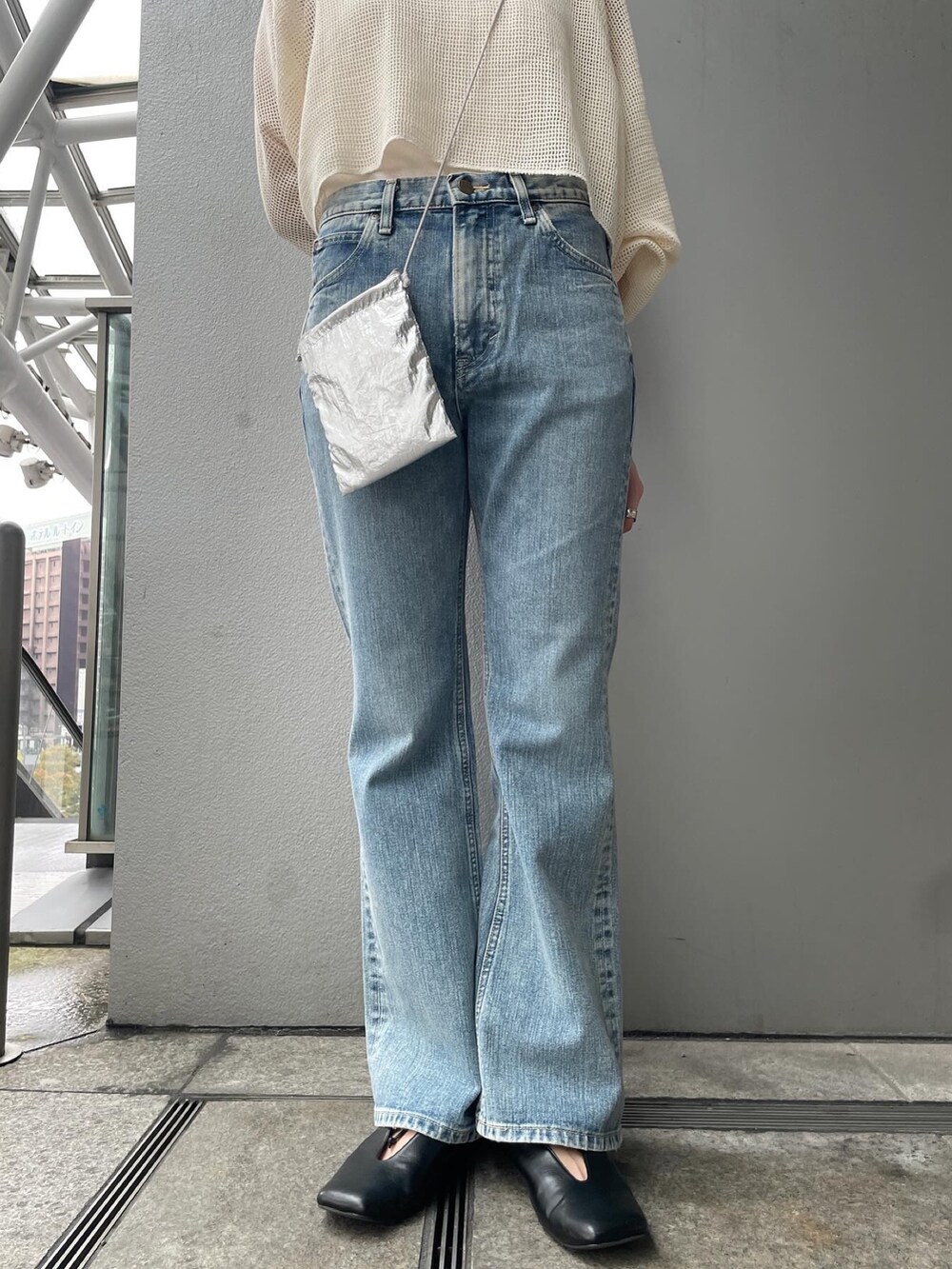 ブルー系のデニムパンツ、ホワイト系のTシャツ/カットソー、ブラック系のパンプスを着用したレディースの春コーディネートの4枚目の写真