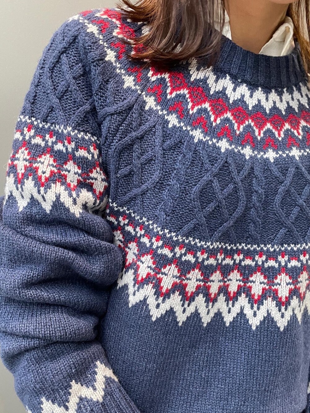 ブルー系のニット/セーター、ホワイト系のシャツ/ブラウス、ブルー系のデニムパンツを着用したレディースの秋コーディネートの3枚目の写真