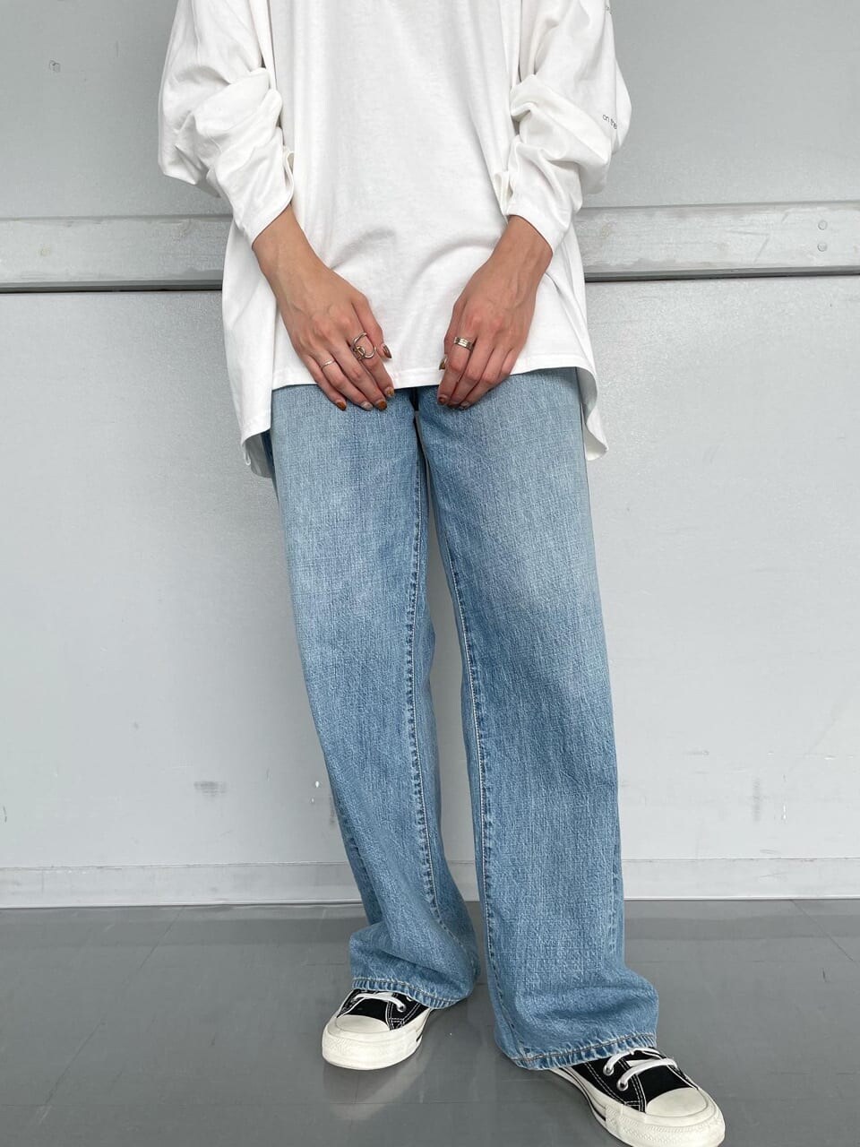 グリーン系のエコバッグ/サブバッグ、ブルー系のデニムパンツ、ホワイト系のTシャツ/カットソーを着用したレディースの夏コーディネートの2枚目の写真