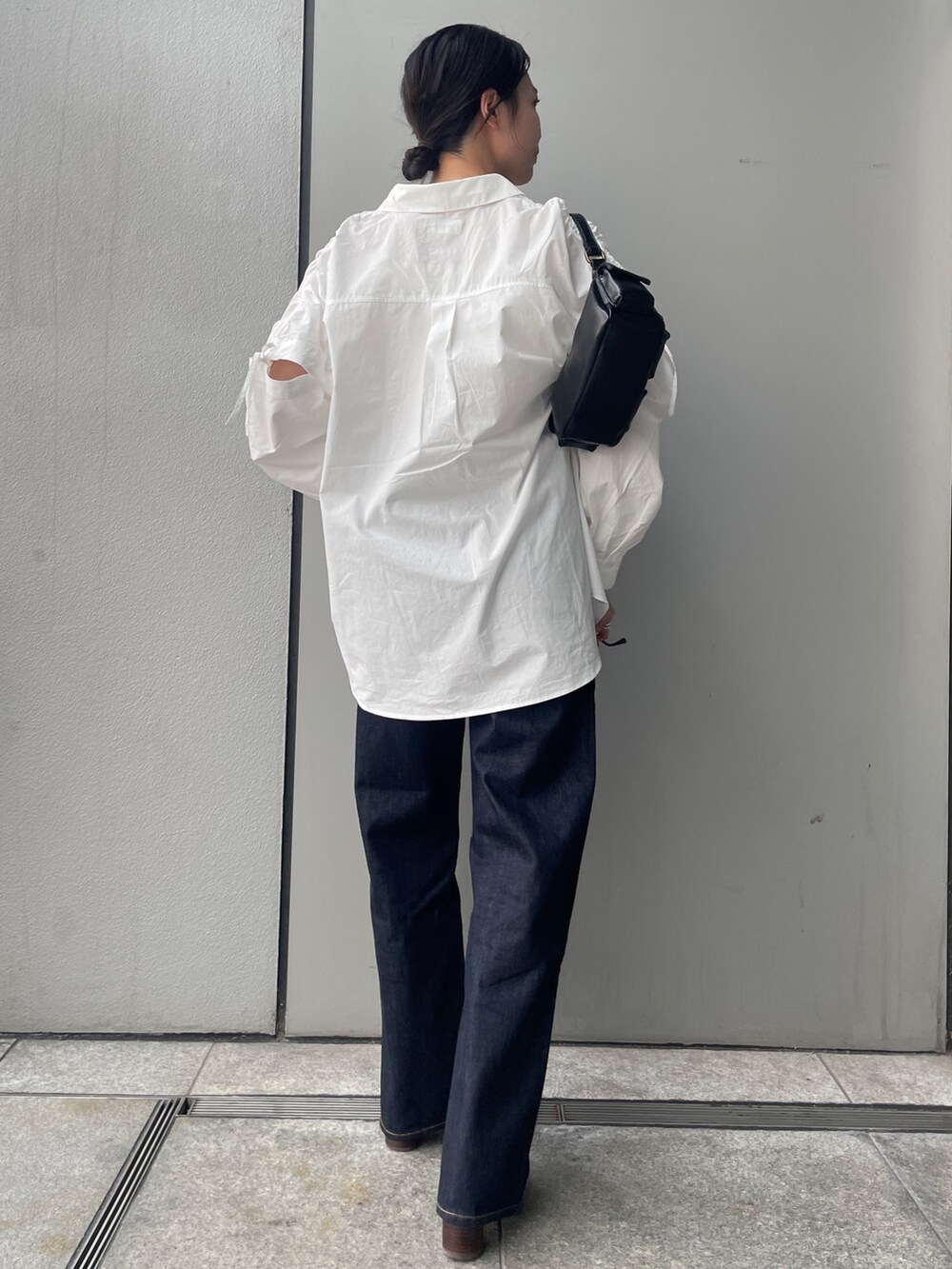 ブルー系のデニムパンツ、ホワイト系のシャツ/ブラウス、ホワイト系のキャミソールを着用したレディースの夏コーディネートの3枚目の写真