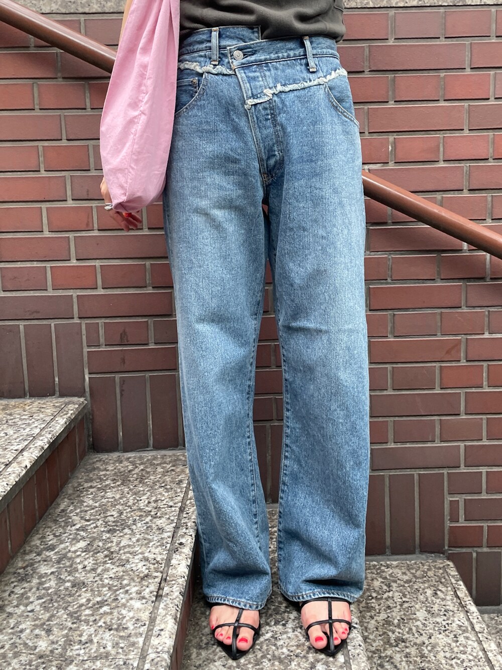 ピンク系のトートバッグ、ブルー系のデニムパンツ、グレー系のタンクトップを着用したレディースの夏コーディネートの5枚目の写真