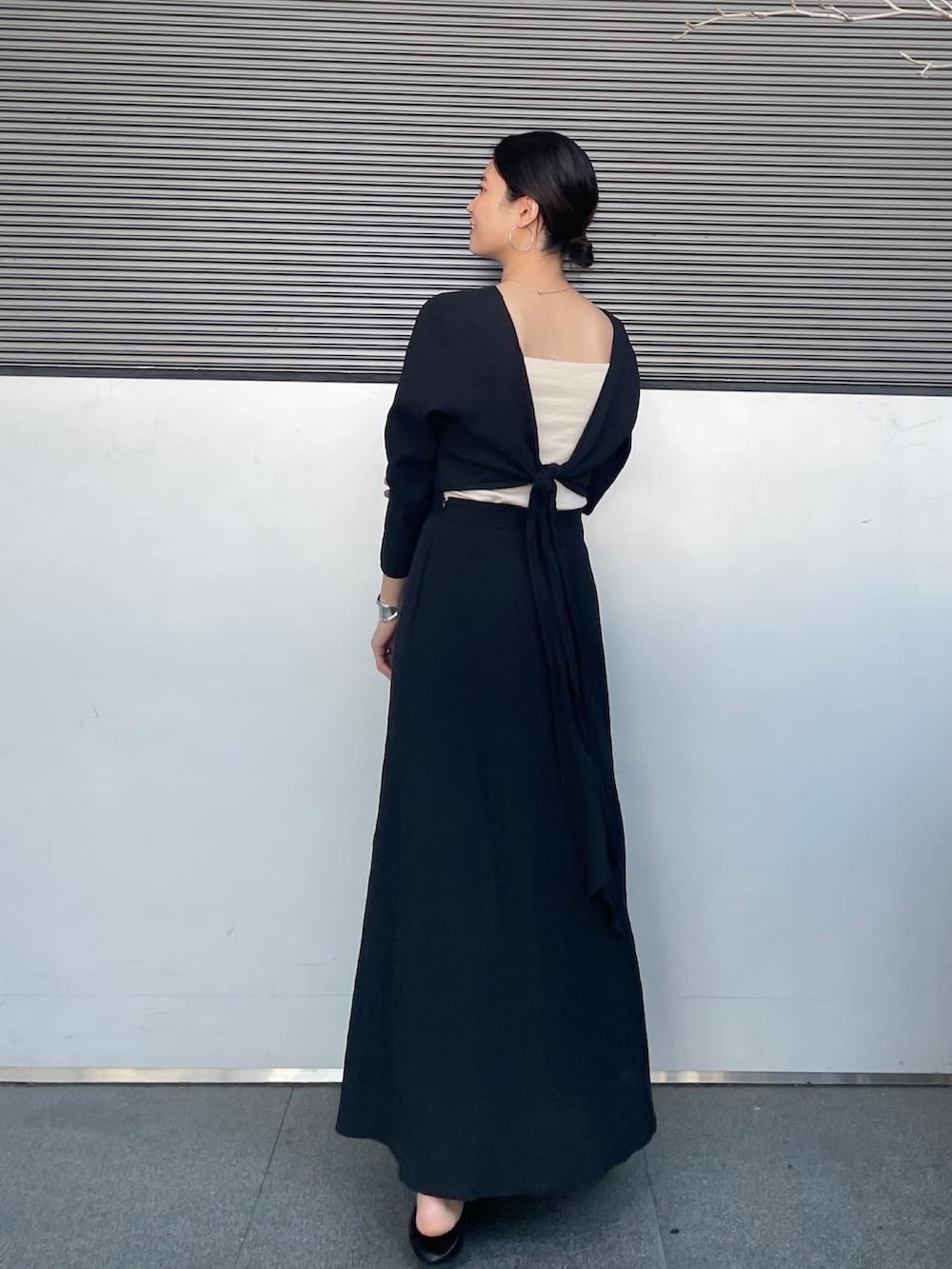 ブラック系のワンピース、ブラック系のパンプスを着用したレディースの春コーディネートの2枚目の写真