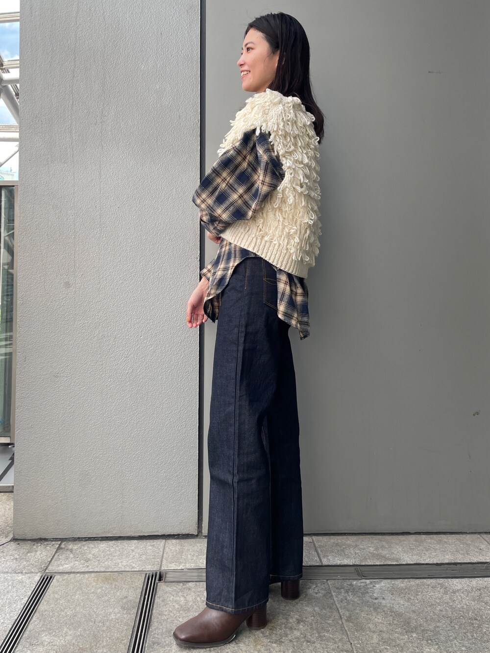 ブルー系のデニムパンツ、ブルー系のシャツ/ブラウス、ホワイト系のベストを着用したレディースの秋コーディネートの2枚目の写真