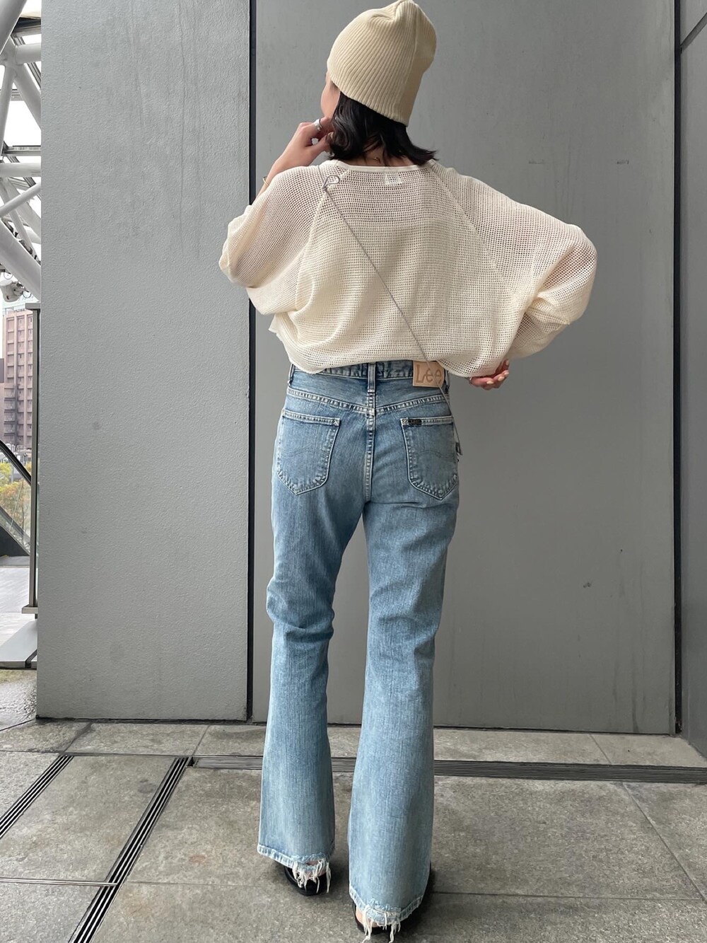 ブルー系のデニムパンツ、ホワイト系のTシャツ/カットソー、ブラック系のパンプスを着用したレディースの春コーディネートの2枚目の写真