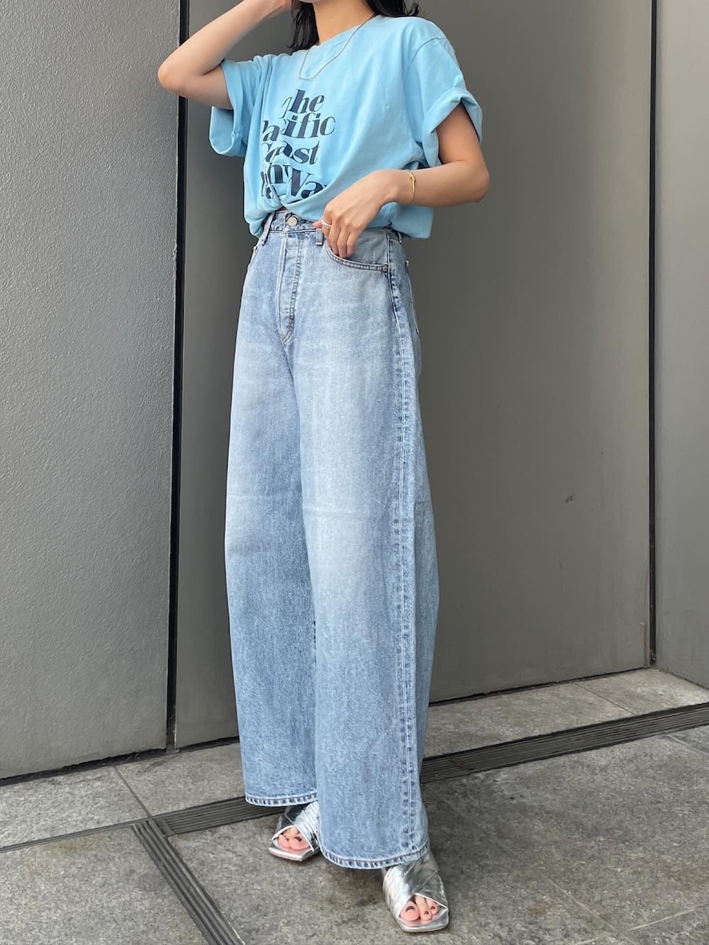 ブルー系のデニムパンツ、ブルー系のTシャツ/カットソー、シルバー系のサンダルを着用したレディースの夏コーディネートの3枚目の写真