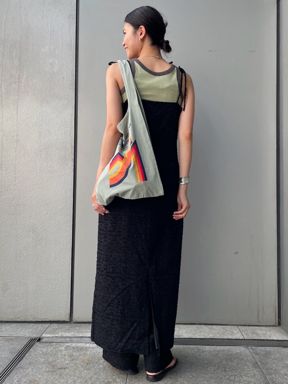 ブラック系のワンピース、グリーン系のタンクトップ、グリーン系のエコバッグ/サブバッグを着用したレディースの夏コーディネートの3枚目の写真