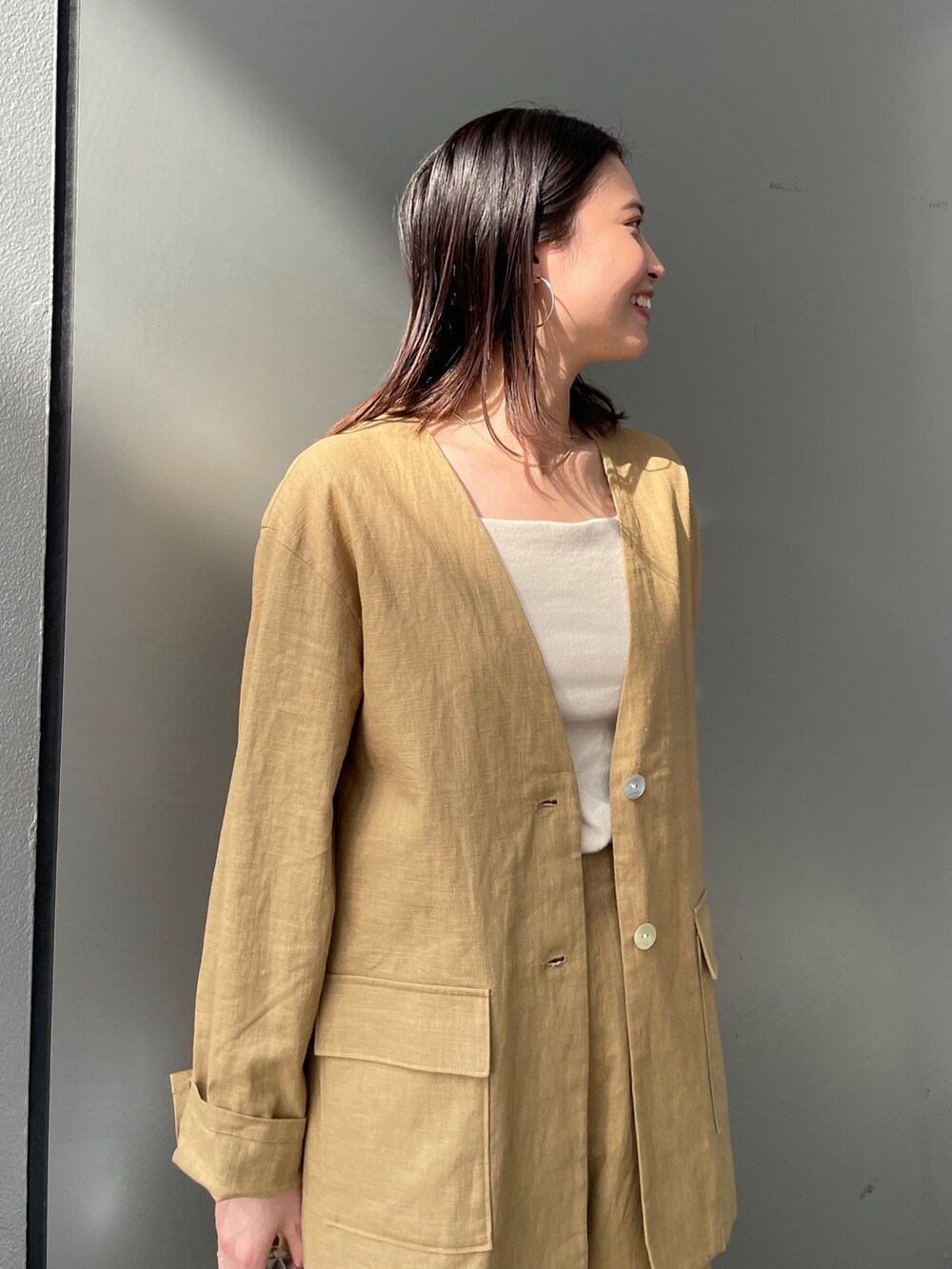 ベージュ系のテーラードジャケット、ベージュ系のその他パンツ、ホワイト系のキャミソールを着用したレディースの春コーディネートの5枚目の写真