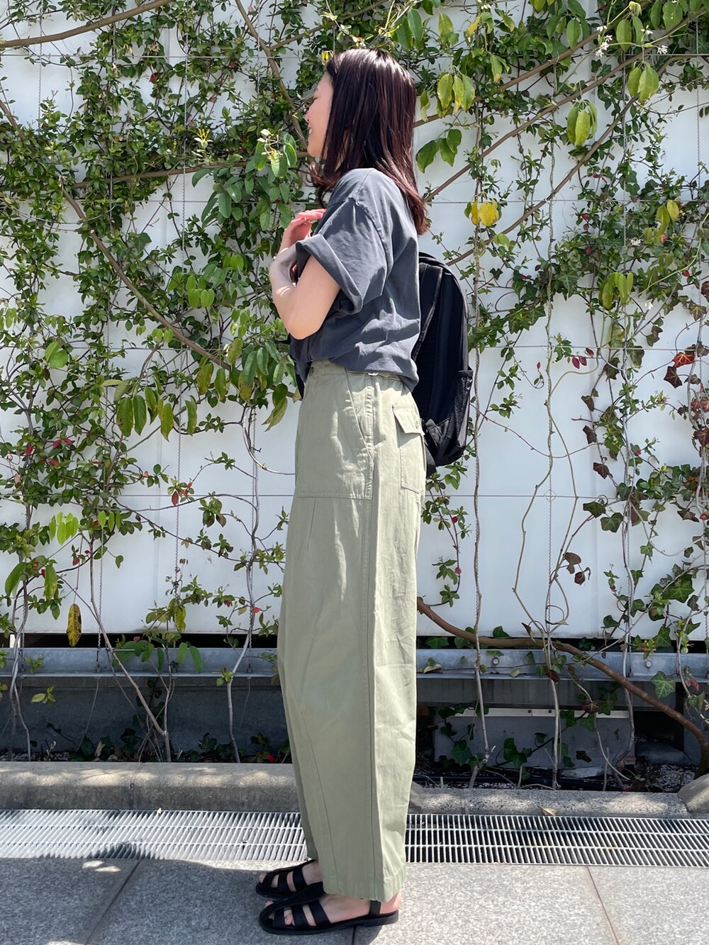 グレー系のTシャツ/カットソー、グリーン系のその他パンツ、ブラック系のサンダルを着用したレディースの春コーディネートの2枚目の写真