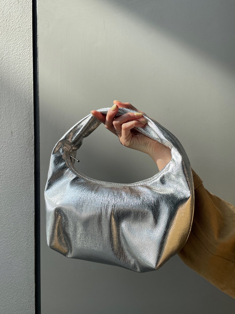 ベージュ系のテーラードジャケット、ベージュ系のその他パンツ、ホワイト系のキャミソールを着用したレディースの春コーディネートの6枚目の写真