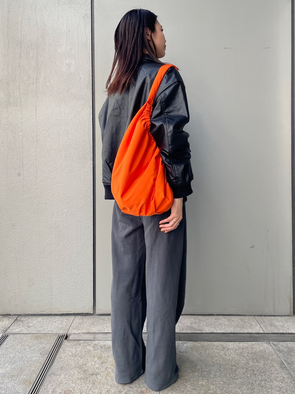 グレー系のスウェットパンツ、ブラック系のブルゾン、グレー系のニット/セーターを着用したレディースの秋コーディネートの2枚目の写真